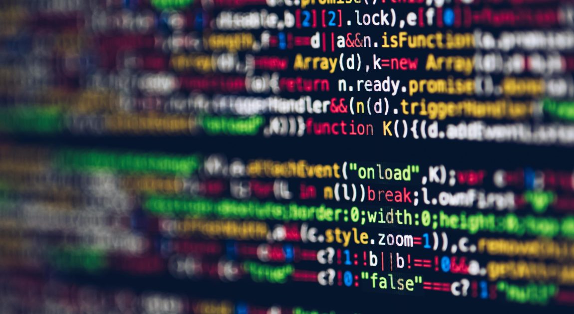 コードが羅列されたPC画面が広がる様子。富士ソフト株式会社が「新価値創造カンパニー」というビジョンのもと、AIやIoTなどの先進技術とシステムインテグレーション力を駆使し、顧客のビジネス変革を支援するITソリューションを提供していることを表している。